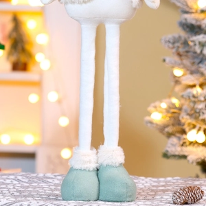 Plush Christmas gnome doll with long legs and green shoes on a festive background