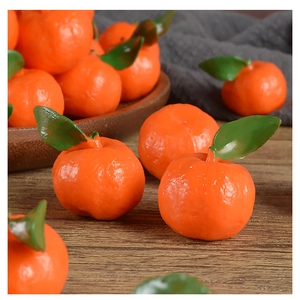 Macro detail of miniature PVC oranges with realistic skin texture and green leaves