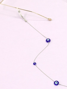 Detail of silver chain eyewear strap featuring blue evil eye beads and rubber loops