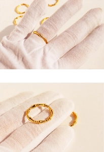 Detailed view of bamboo joint gold rings showcased on a white gloved hand for elegance