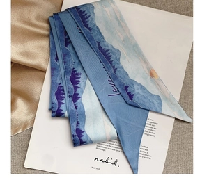 Detailed close-up of a blue silk twilly scarf with landscape pattern and love text