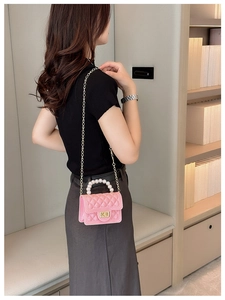 Detailed close-up of pink quilted jelly bag featuring a pearl handle and chain strap