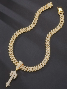 Macro detail of high-shine gold Cuban chain necklace with iced-out cross sword pendant