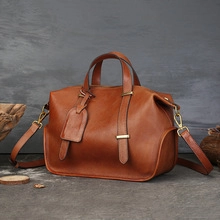 Nahaufnahme der braunen Ledertasche mit feiner Textur, stabilen Henkeln und edlen Metalldetails.