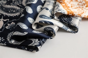 Macro detail of high-quality silk scarf fabric with classic paisley patterns and soft sheen