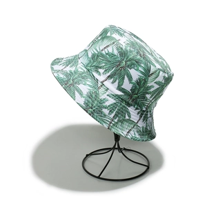 Detail of tropical bucket hat with green palm tree print on a wire display stand