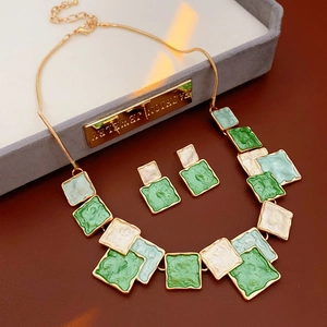 Détail du collier et boucles d'oreilles carrés émaillés vert et or au style bohème