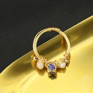Handcrafted gold wire-wrapped ring with natural white pearls and a purple floral gemstone
