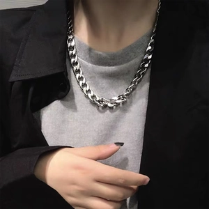 Silver Cuban link chain necklace shown on a model wearing a black jacket and grey t-shirt