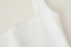 Détail du haut débardeur blanc en maille avec de larges bretelles et finitions soignées