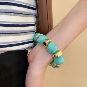 Close-up of marble pattern acrylic beads and gold metal spacers on a fashion bracelet