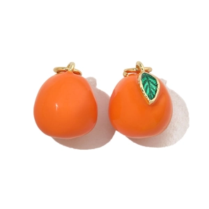 Detail of persimmon fruit charm pendants with orange enamel and gold metal loops