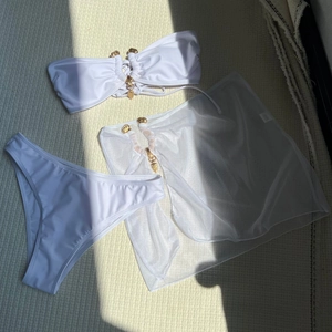 Détails de l'ensemble bikini blanc avec boucles cœur dorées et paréo en résille assorti