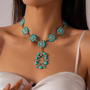 Macro detail of vintage gold necklace with turquoise stones and shimmering rhinestones