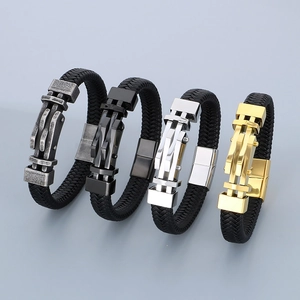 Dettaglio di quattro bracciali in pelle intrecciata con fibbie metalliche in oro e argento