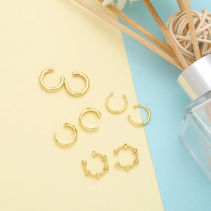 Detail of four gold ear cuff styles including smooth, faceted and beaded metal designs