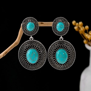 Vintage silver-tone earrings with turquoise stones and hollow floral patterns on branches