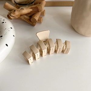 Detail of matte cream rectangular hair claw clip with strong metal spring