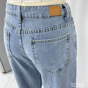 Détail de la taille haute, des poches arrière et du patch en cuir sur un jean vintage