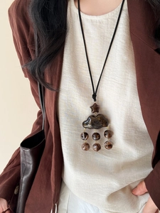 Détail d'un pendentif nuage en résine avec perles marbrées sur un long collier cordon