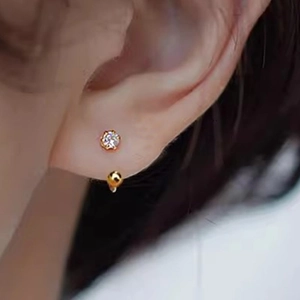 Golden C-shaped stainless steel screw-back earring with round zircon on the ear lobe