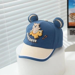 Détail de la casquette enfant bleu marine avec oreilles 3D et écusson d'ours dessin