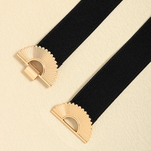 Detailed close-up of a black elastic waist belt with a golden semicircular metal buckle