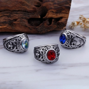 Macro shot of silver military ring with red and blue stones and university eagle reliefs