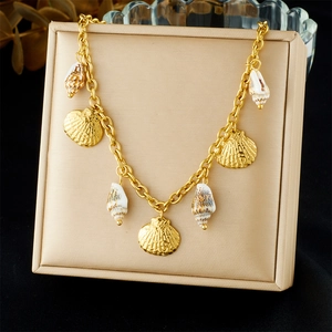 Gold bohemian necklace with scallop and seashell charms on a luxury display stand