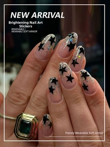 Detail of almond-shaped pink gradient press-on nails with stars and silver glitter