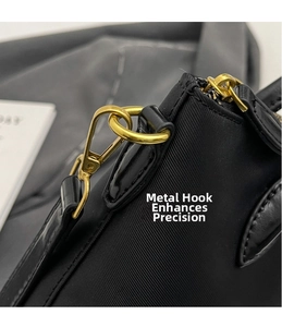 Detailed close-up of premium gold swivel hooks and nylon fabric on black crossbody bag