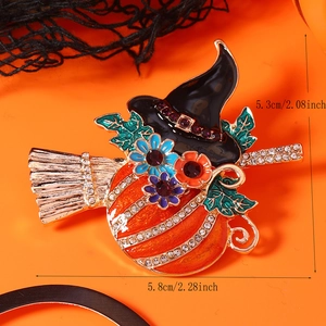 Detail of Halloween witch hat and pumpkin brooch with vibrant orange enamel and rhinestones