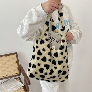 Close-up of plush faux fur tote bag with heart pattern and soft texture for winter