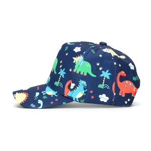 Détail d'une casquette enfant bleu marine avec imprimés dinosaures colorés et palmiers