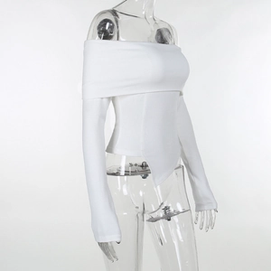 Detail view of the fine ribbed knit texture and asymmetric pointed hem on the white off-shoulder top