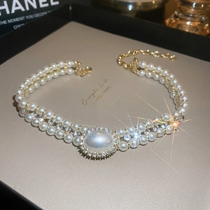 Gros plan sur un collier de perles double rang avec pendentif ovale en pierre de lune