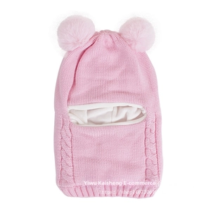Detail of pink knitted baby balaclava with dual pom-poms and soft warm fleece lining