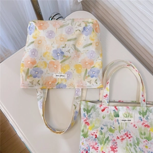 Vue détaillée de deux sacs fourre-tout en toile à motifs floraux élégants et colorés