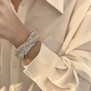 Macro view of wide silver textured cuff bracelet with elegant spiral lava-like patterns
