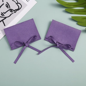 Detail of a bright purple microfiber jewelry pouch with an elegant ribbon bow closure