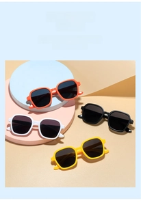 Flat lay of retro square children's sunglasses in orange, white, black and yellow colors
