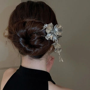 Detailed view of silver flower hair pin with tassels on elegant updo hairstyle