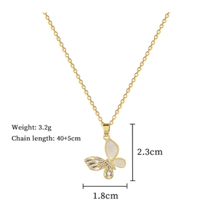 Detail view of gold butterfly pendant with mother of pearl and cubic zirconia stones
