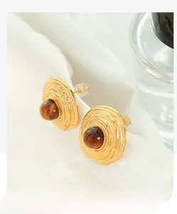 Detail of French vintage gold earrings with spiral texture and tiger eye stone inlay