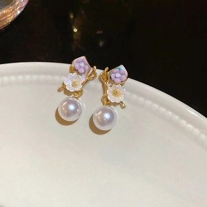 Vue détaillée de boucles d'oreilles fleurs roses avec perles et papillons dorés