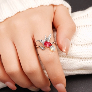 Detailopname van kolibrie ring met een rode peervormige steen en pavé zirkonia details