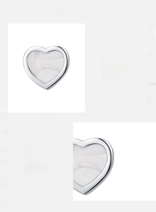 Dettaglio di orecchini a cuore in argento 925 con texture perlata e lucidatura