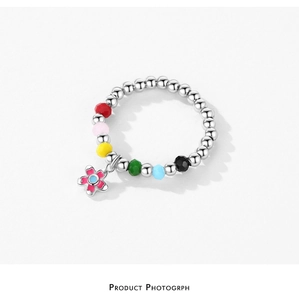 Macro detail of S925 silver beaded ring with colorful multifaceted stones and flower charm