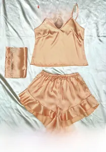 Détail d'un ensemble caraco en satin champagne avec short à volants et pochette assortie