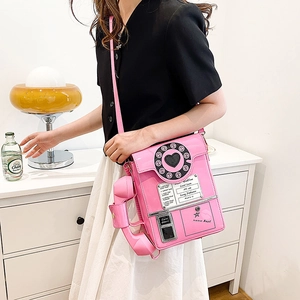 Close-up of pink telephone-shaped crossbody bag with rotary dial and 'Hotline' text